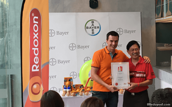 Ludovic Rassat, Country Division Head Singapore & South Asia Bayer Consumer Health, receives the certificate from Mr Ong, Singapore Book of Records, certifying that Boost & Slide is Singapore's longest street water slide.