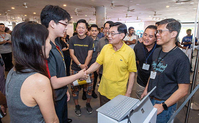 Code in the Community graduate Aiden McEwan presenting his project to DPM Heng Swee Keat.