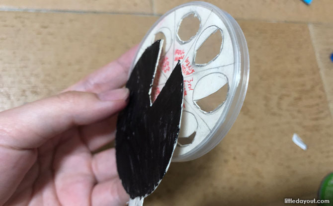 fitting the card with the phases of the moon into the snack canister’s cap