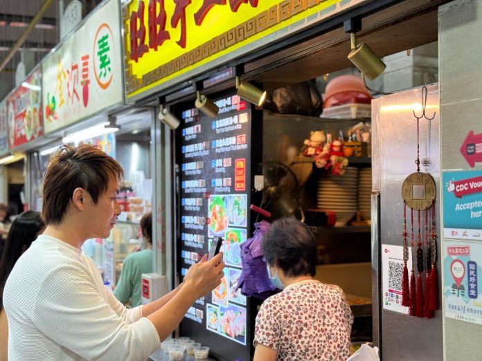 Photo 1_Customer using PayLah! to scan and pay for his meal at a hawker centre paylah hawker
