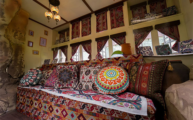 The interior of the Safranbolu houses decorated like an Ottoman-era home with Turkish mosaic lamps and kilim rugs