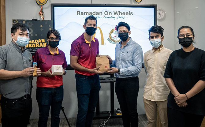 McDonald’s Singapore General Counsel & Legal Director Faz Hussen (third from the left) presents meals in the form of food voucher to 4PM President, Nassar Mohamad Zain