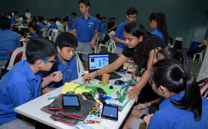 Nila Govindaraju, intern at Science Centre Singapore assisting fellow e-waste warriors as they apply their skills of coding and computational thinking. Nila designed the blended learning content and simplified the core robotic modules participants used during Caltex Fuel Your School - Tech Jam 2018.