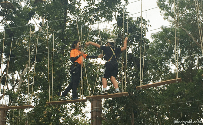 Instructor assisting a participant on the Forest Adventure rope course