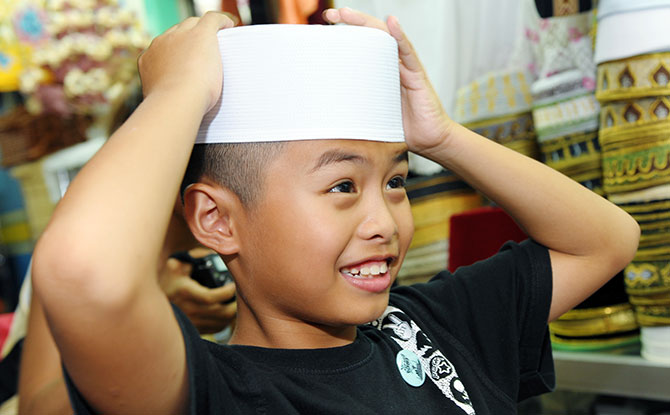 Malay boy with hands on head
