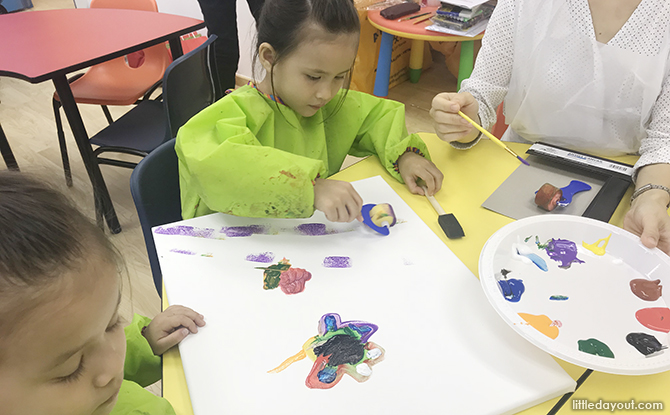 Girl and sibling painting