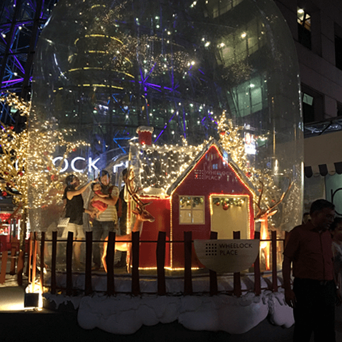 The snow globe at night, with shoppers inside.