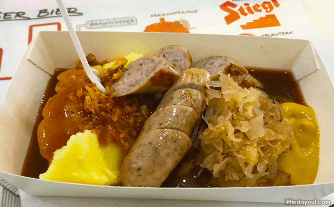 Ready to tuck in to a meat of bratwurst, mashed potatoes and sauerkraut.