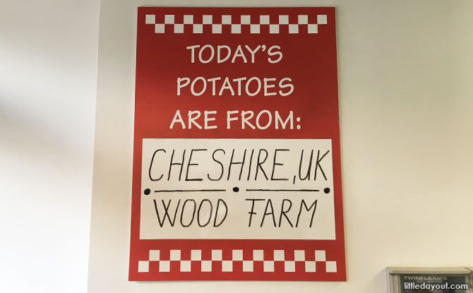 Sign at a Five Guys London outlet stating where the potatoes are sourced from.