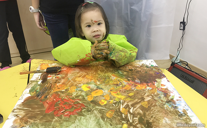 Girl with paint on face and hands