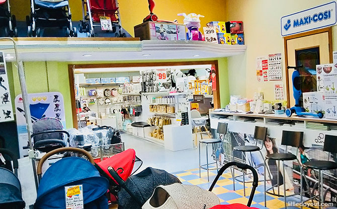 Cots on display, alongside some ride-on cars, Bfree milk bottles, dehumidifiers, and other baby essentials, like bibs and nappy bags