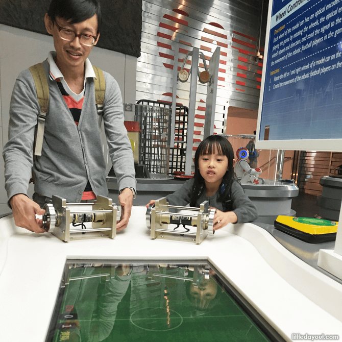 Father and daughter having scientific fun at the robotics gallery.