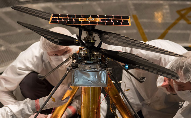 Members of the NASA Mars Helicopter team inspect the flight model (the actual vehicle going to the Red Planet), inside the Space Simulator, a 25-foot-wide (7.62-meter-wide) vacuum chamber at NASA's Jet Propulsion Laboratory in Pasadena, California