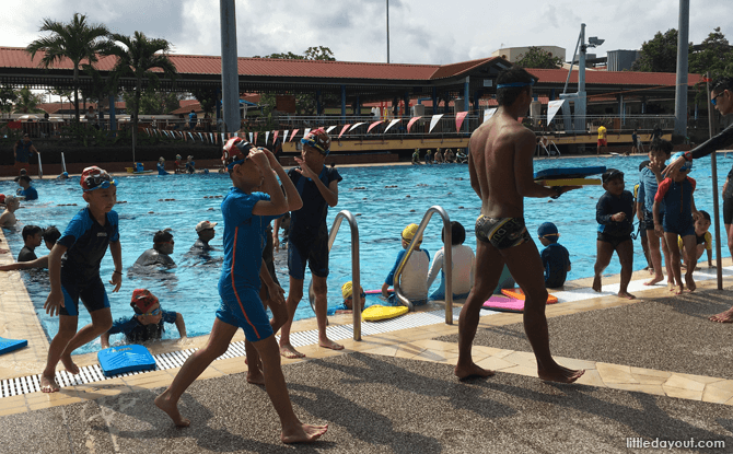 A crowded public pool with many swim classes going on at the same time