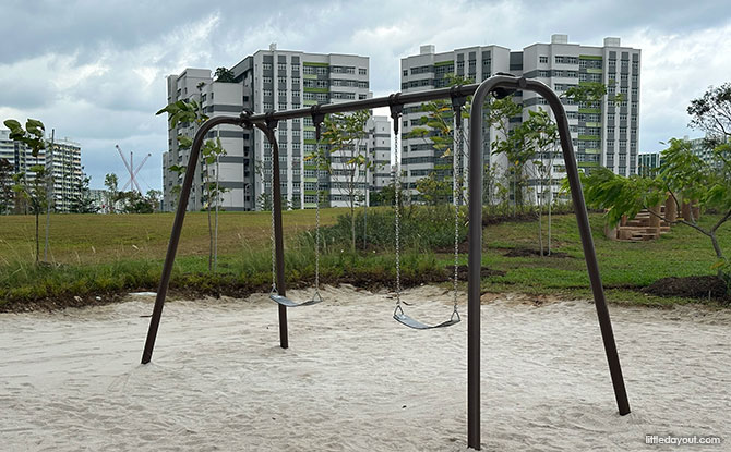 swings in a sandy play area