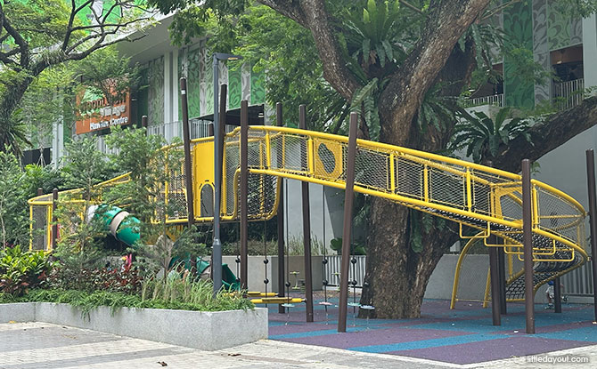 Woodleigh Village Playground: The Yellow Curl Snaking Around the Trees at the Hawker Centre